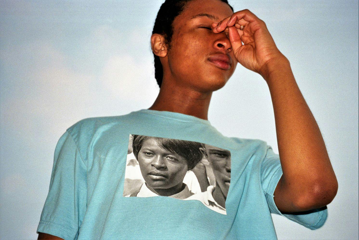 A photograph of a T-shirt by Supreme being worn by a model, featuring a photograph by Roy DeCarava.