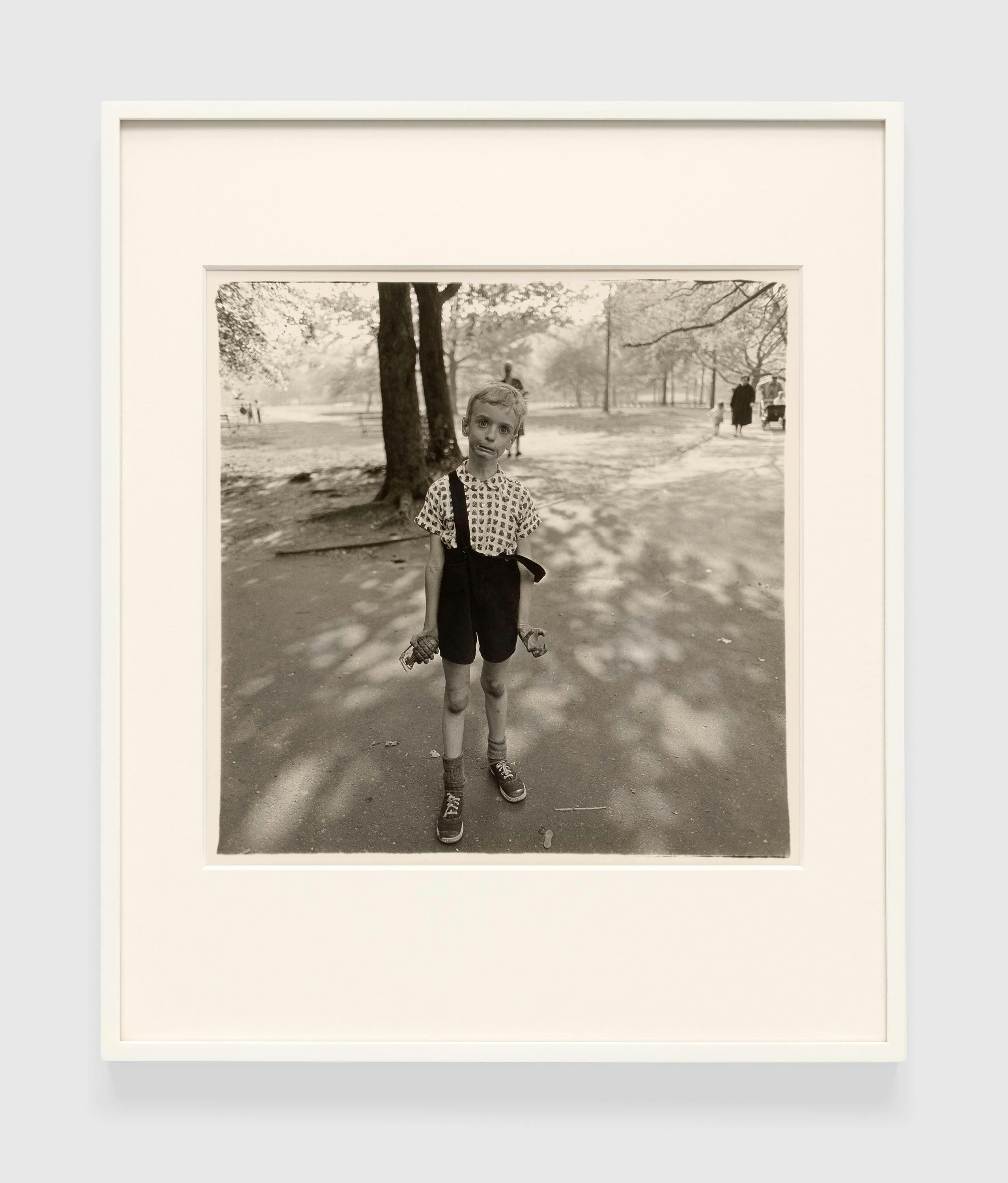 A gelatin silver print by Diane Arbus, titled Child with a toy hand grenade in Central Park, N.Y.C. 1962, dated 1962.