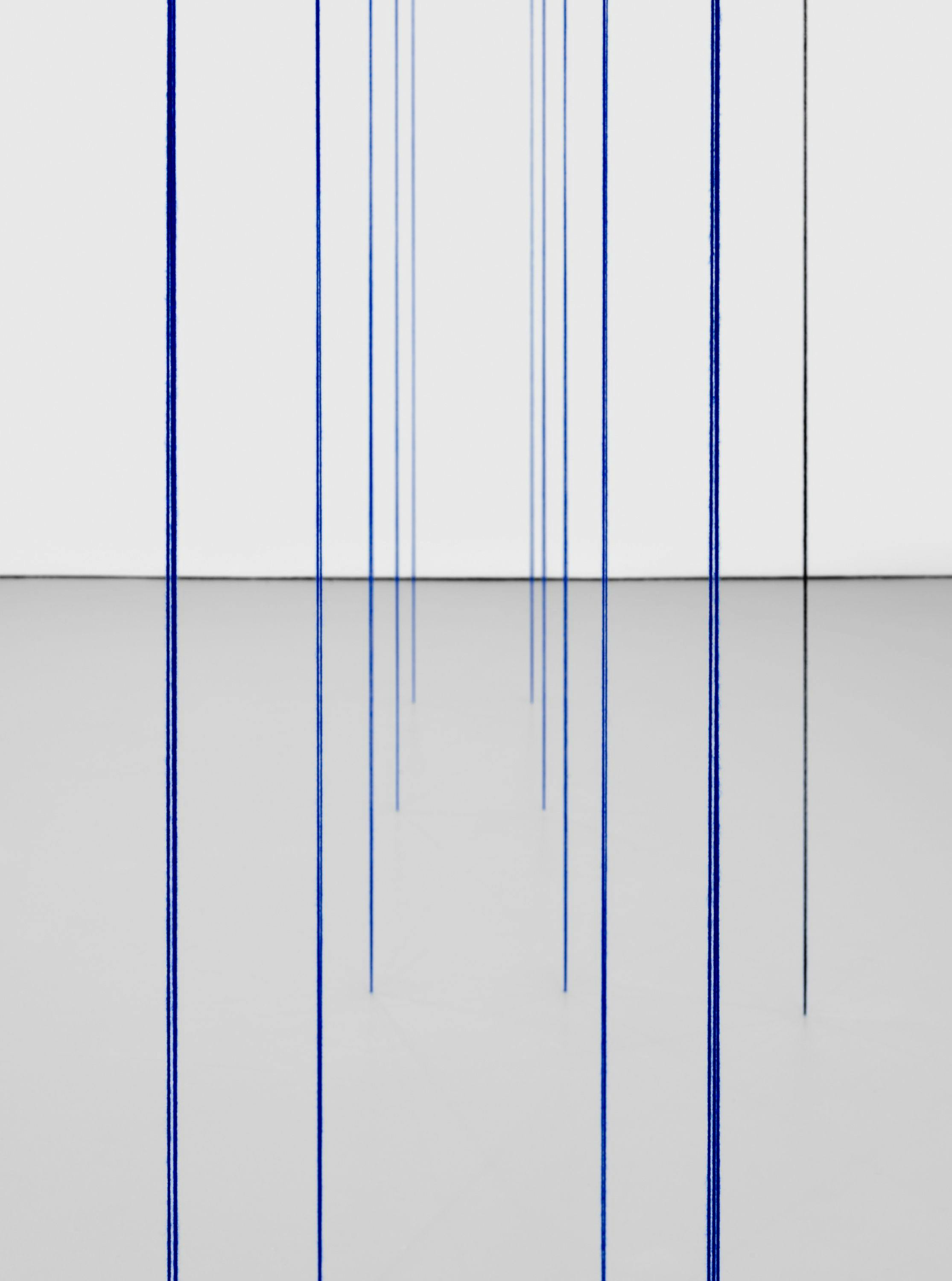 A detail from a black, blue, white, and light yellow acrylic yarn artwork by Fred Sandback, titled Untitled (Sculptural Study, Eighteen-part Architectonic Vertical Construction), 1987 and 2018.